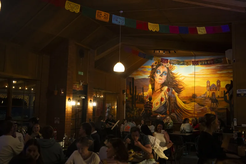 The Catrina mural over a full room at La Catrina